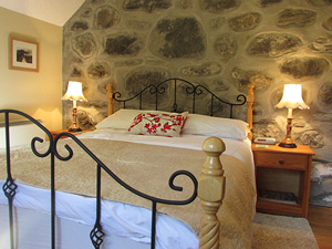 double bedroom with stone wall